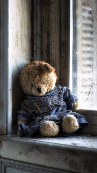 Hình ảnh gấu bông ngồi buồn bên cửa sổ