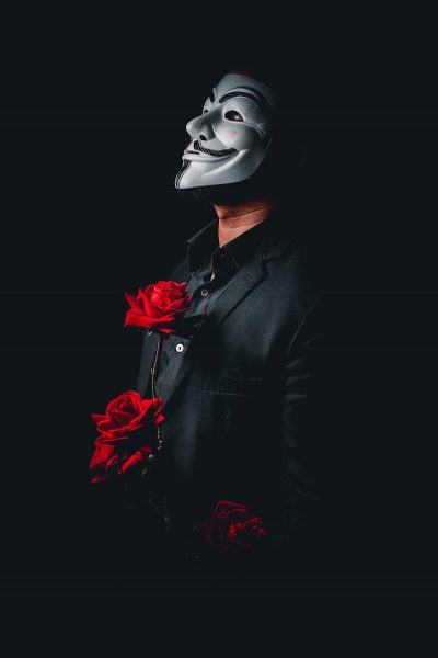 hình ảnh một hacker trong bộ vest đen với bông hồng đỏ