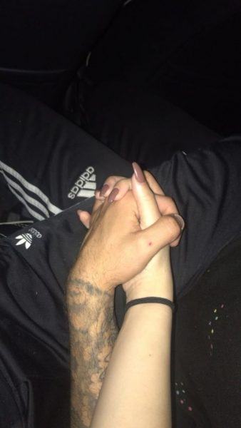 hình ảnh một cặp đôi nắm tay nhau trên nền tối