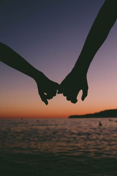 hình ảnh một cặp đôi nắm tay nhau trên bãi biển
