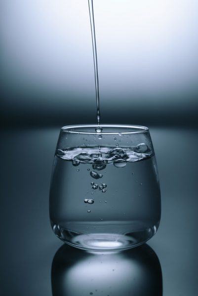 nước lấp lánh rơi vào cốc nước