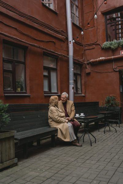 Hình ảnh đôi vợ chồng già ngồi trên chiếc ghế đá bên đường