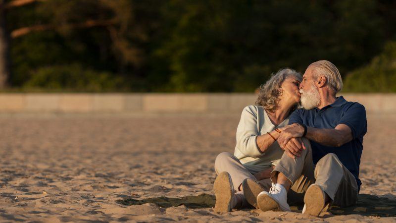 Hình ảnh người già hôn nhau hạnh phúc trên bãi cát