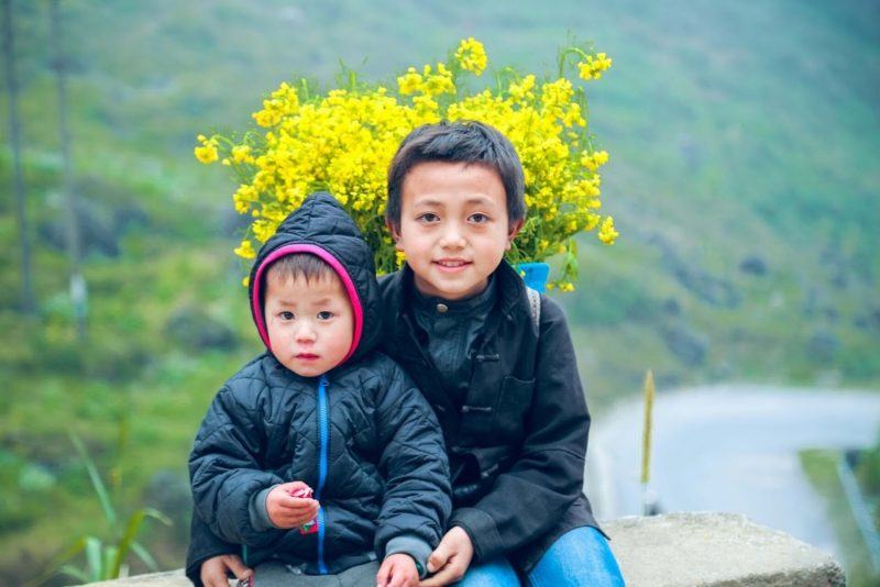 hình ảnh những đứa trẻ hạnh phúc với bông hoa trên lưng